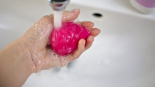 An image showing a person washing a beauty blender