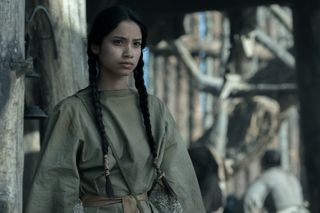 shawnee pourier as two moon wearing her hair in braids standing on the camp in american primeval