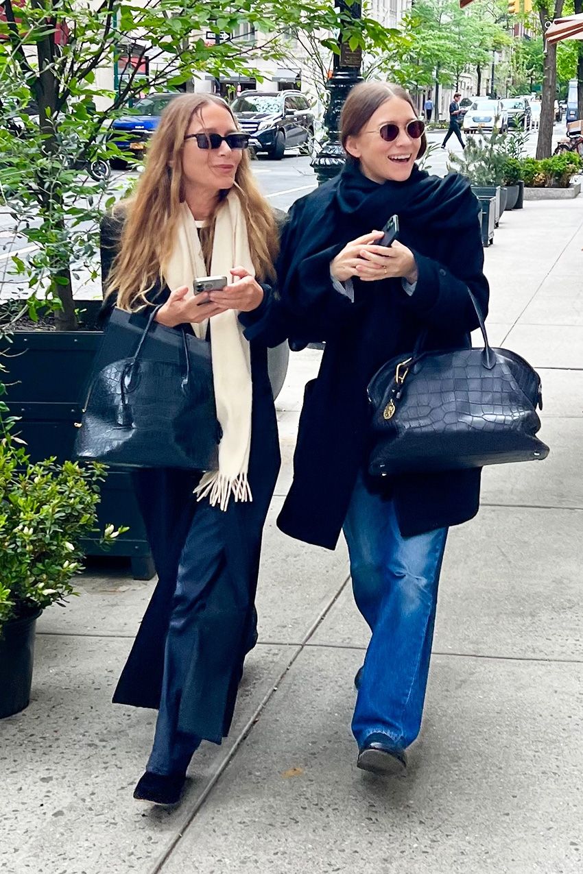 Mary-Kate and Ashley Olsen wearing jackets, scarves, jeans, bowling bags, and flat mules in NYC