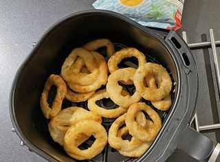 Onion rings in airfryer in kitchen