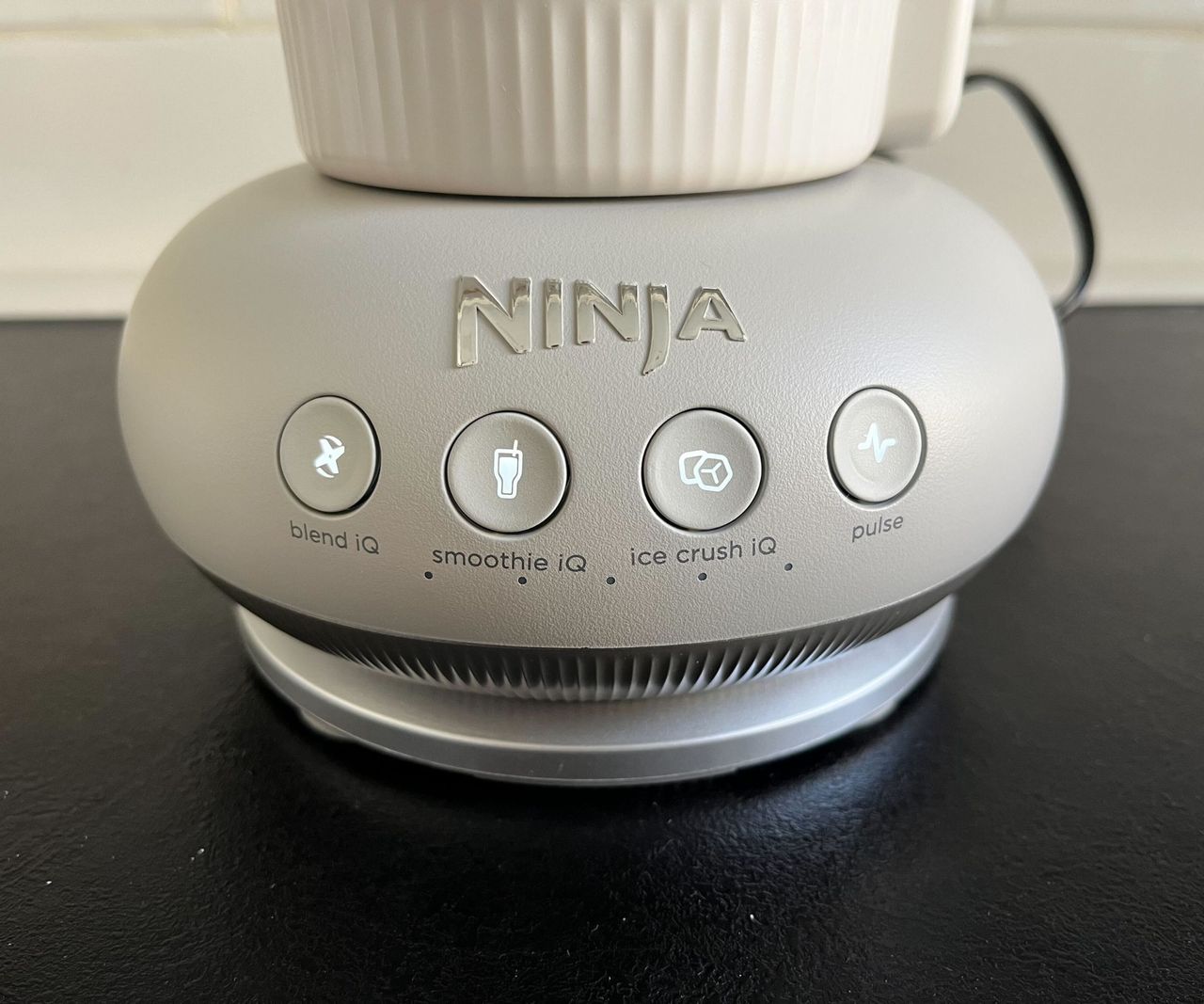 A close up of the Ninja Blendboss base with the blend, smoothie, ice crusher, and pulse buttons illuminated.