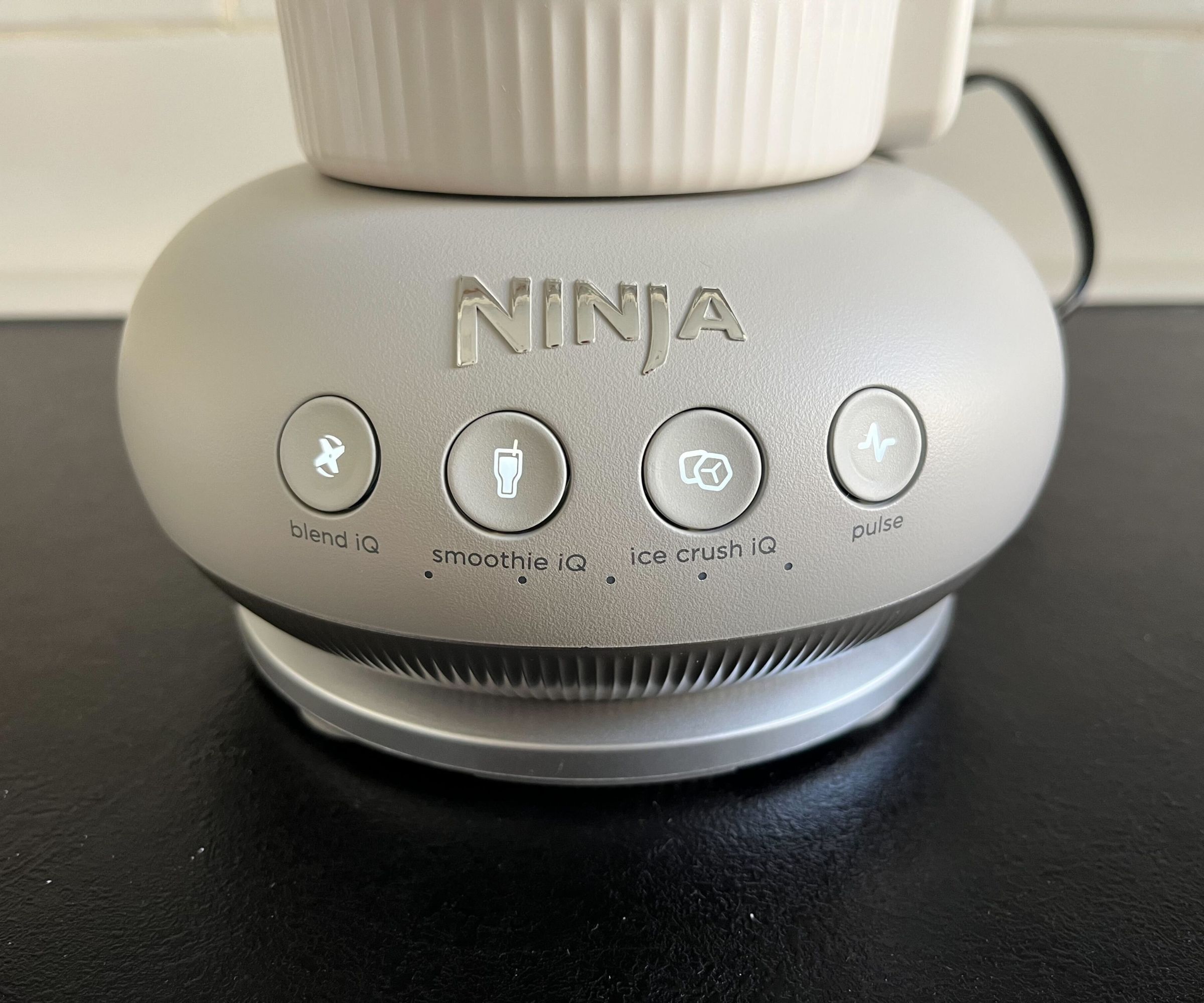 A close up of the Ninja Blendboss base with the blend, smoothie, ice crusher, and pulse buttons illuminated.