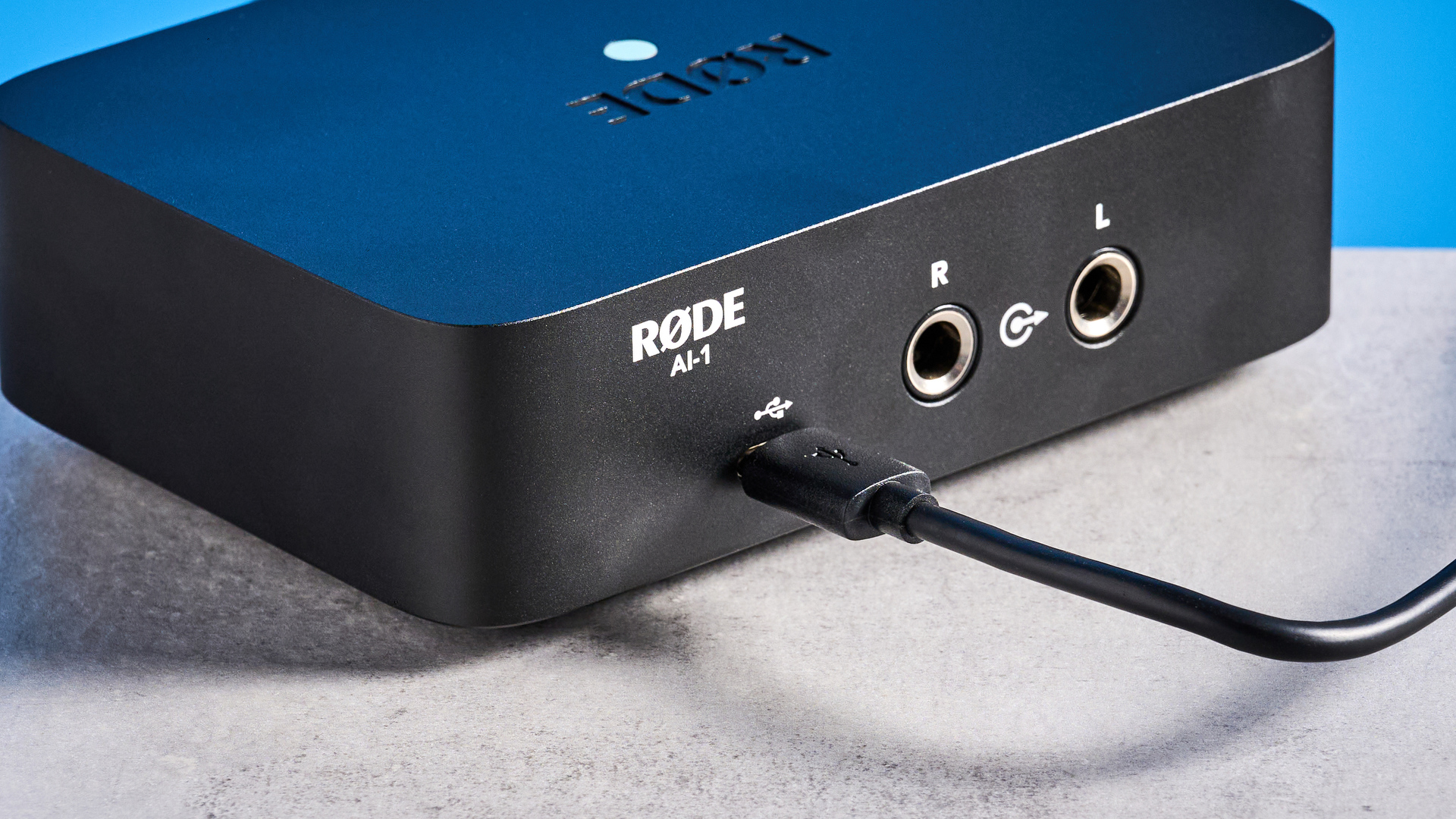 the rode ai-1 audio interface in black with an XLR input, a headphone input, and 2 speaker outputs
