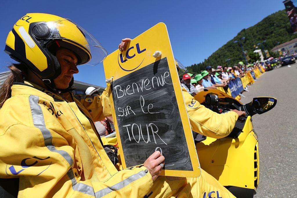 TOPSHOT The board girl writes Welcome on the Tour de France on her information board prior to the start of the 209 km sixteenth stage of the 103rd edition of the Tour de France cycling race on July 18 2016 between MoiransenMontagne and Berne AFP KENZO TRIBOUILLARD Photo credit should read KENZO TRIBOUILLARDAFP via Getty Images