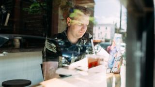 Front-end developer Wes Bos working in a cafe.