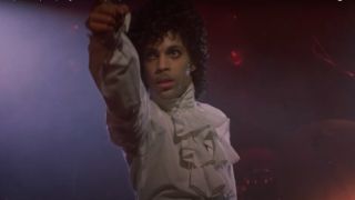 Prince dramatically points while on stage in his puffy shirt in Purple Rain.