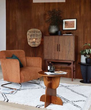 Retro-inspired boho living room with walnut wall paneling and furniture, and burnt orange 70s' inspired armchair.