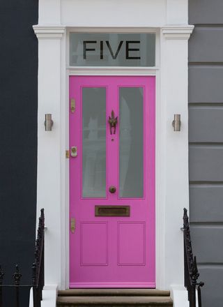 bright pink front door with number etched into glass