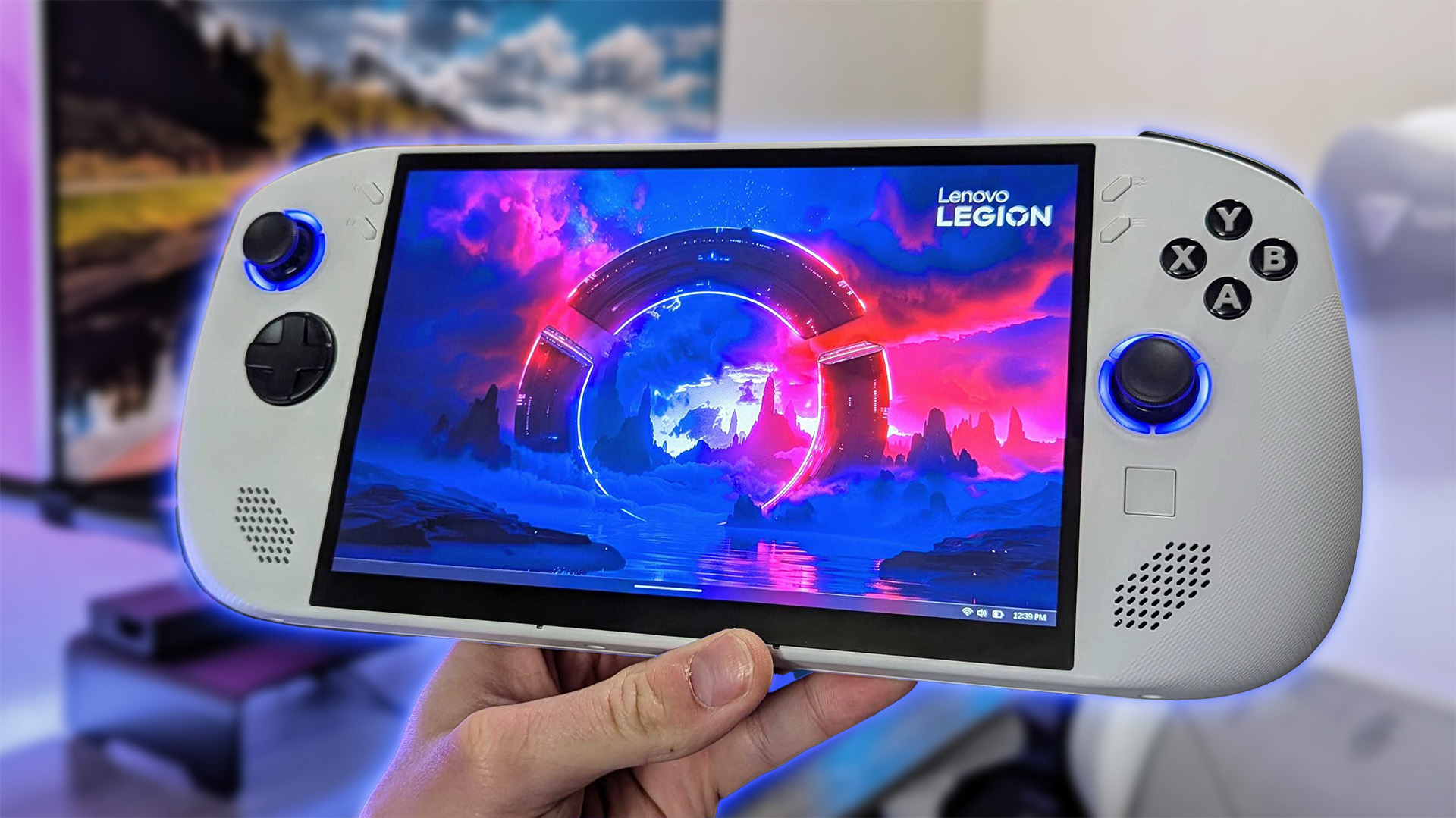 Lenovo Legion Go S gaming handheld in white, running Windows 11, held in front of a blurred gaming room background
