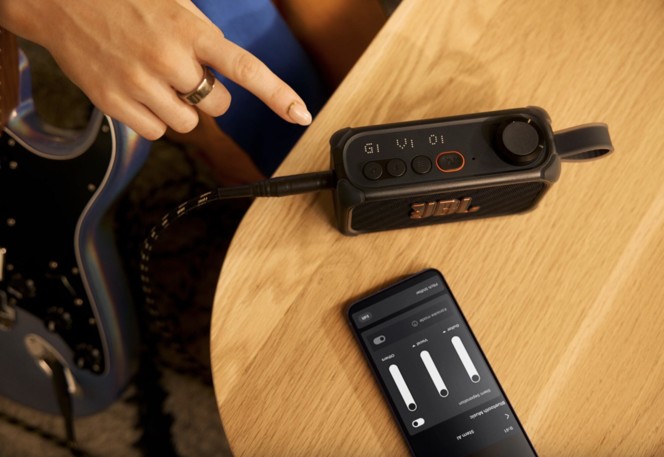 JBL's Bandbox Solo sits on a wood table, with an iPhone below it
