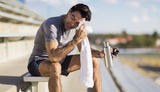 A man pauses on the bleachers to take an exercise break