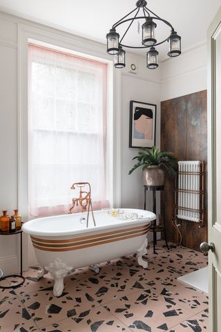 A traditional bathroom with a rolltop bath an pink terrazzo floor