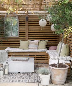 Outdoor living area with wooden slat panels and bench, around modern fire pit