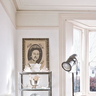 white wall with framed picture and lamp light