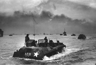 Black and white photo of a US assault craft moving through the waters.