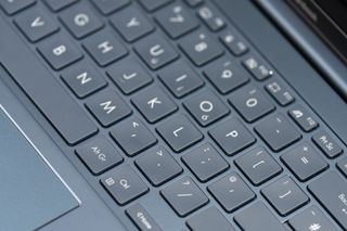 A black ASUS Zenbook 15 OLED laptop sitting on a table