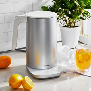 Silver kettle from Zwilling on worktop with oranges and hot drink