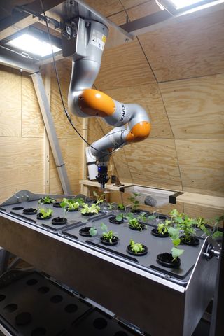 A robot tends to a garden inside the fake moon base.