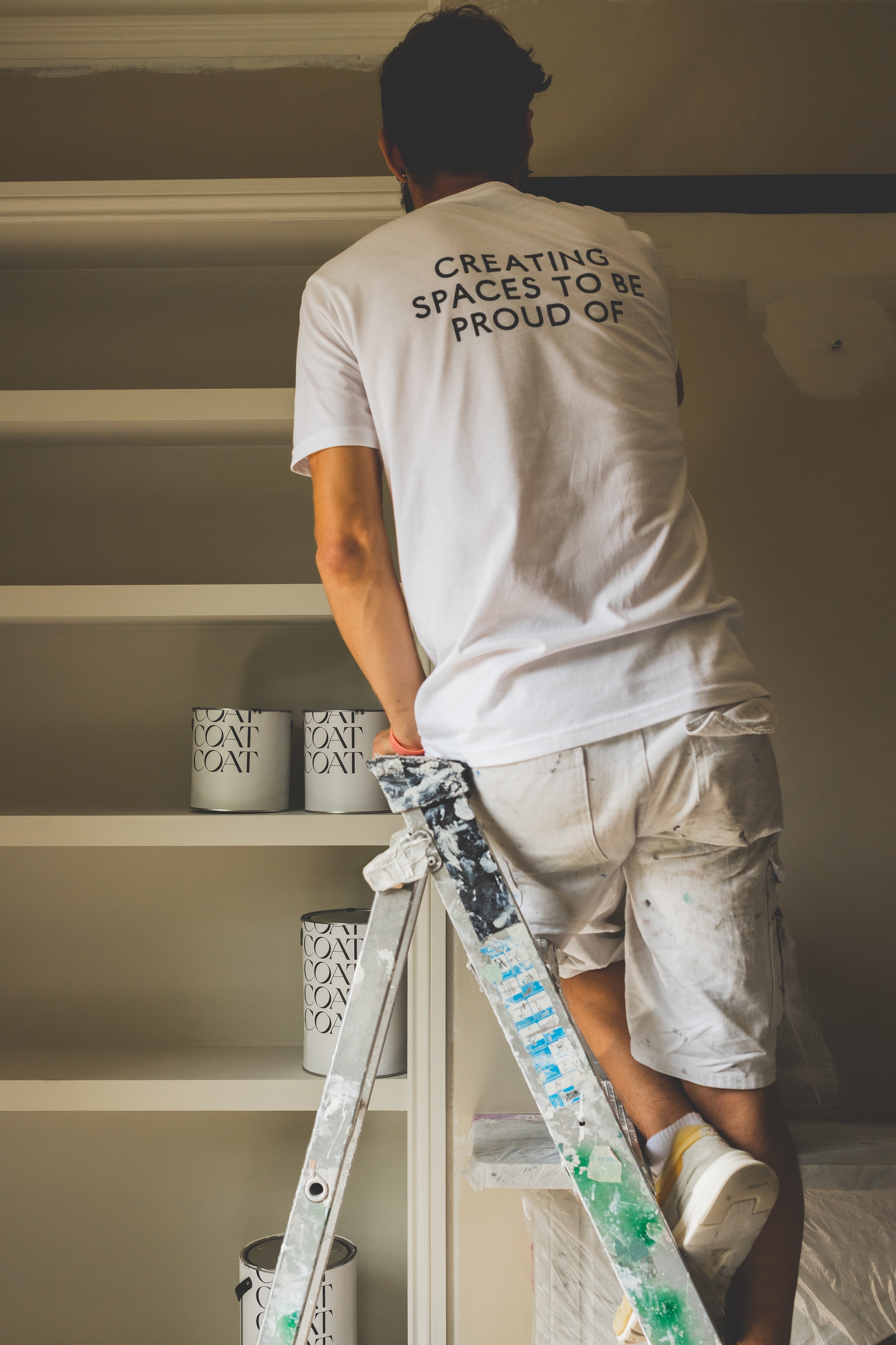 a decorator painting a wall in coat paints