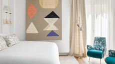 a modern bedroom with art and curtains