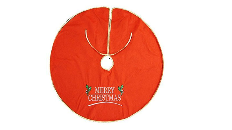A red Christmas tree skirt with embroidered tree branches. It reads Merry Christmas.