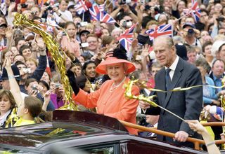 Queen Elizabeth II and Prince Phillip the Duke of Edinburgh ride along the Mall in an open top car on their way to watch a parade in celebration of the Golden Jubilee