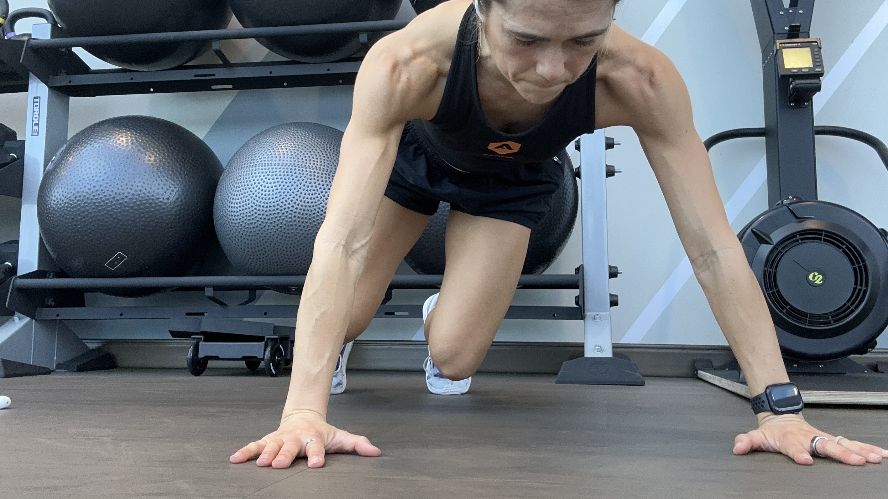 Woman exercising with gym equipment behind her