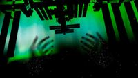 the black silhouette of the international space station is seen against a green screen, with the outline of two hands beneath it