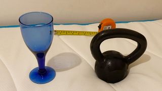 A wine glass, weight and tape measure on the Linenspa Memory Foam Hybrid mattress