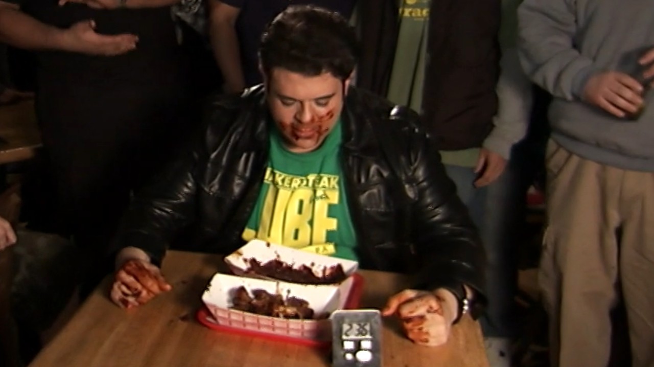 Adam Richman struggles against the hellfire wings