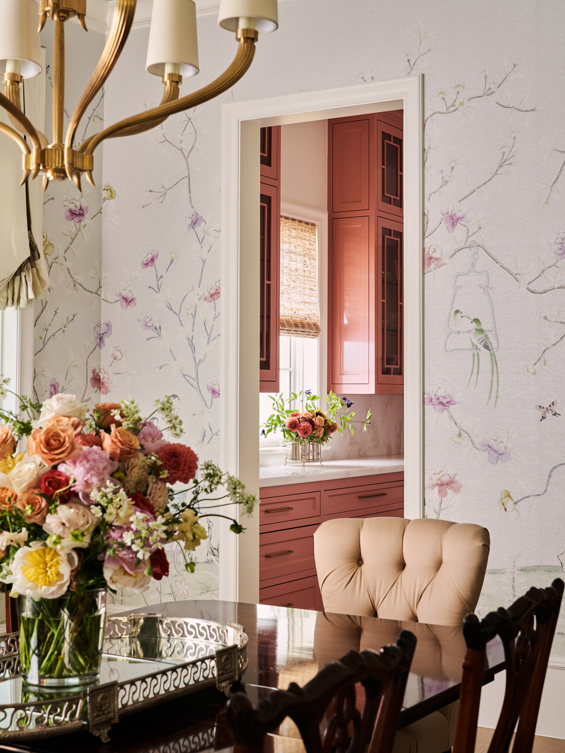 Dining room with floral patterned wallpaper and matching florals on the table