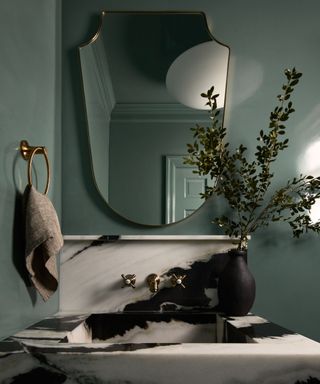 teal painted bathroom with marble sink