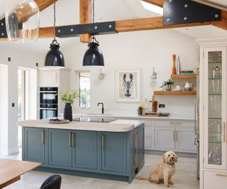 Blue kitchen island, wooden beams, white cabinet