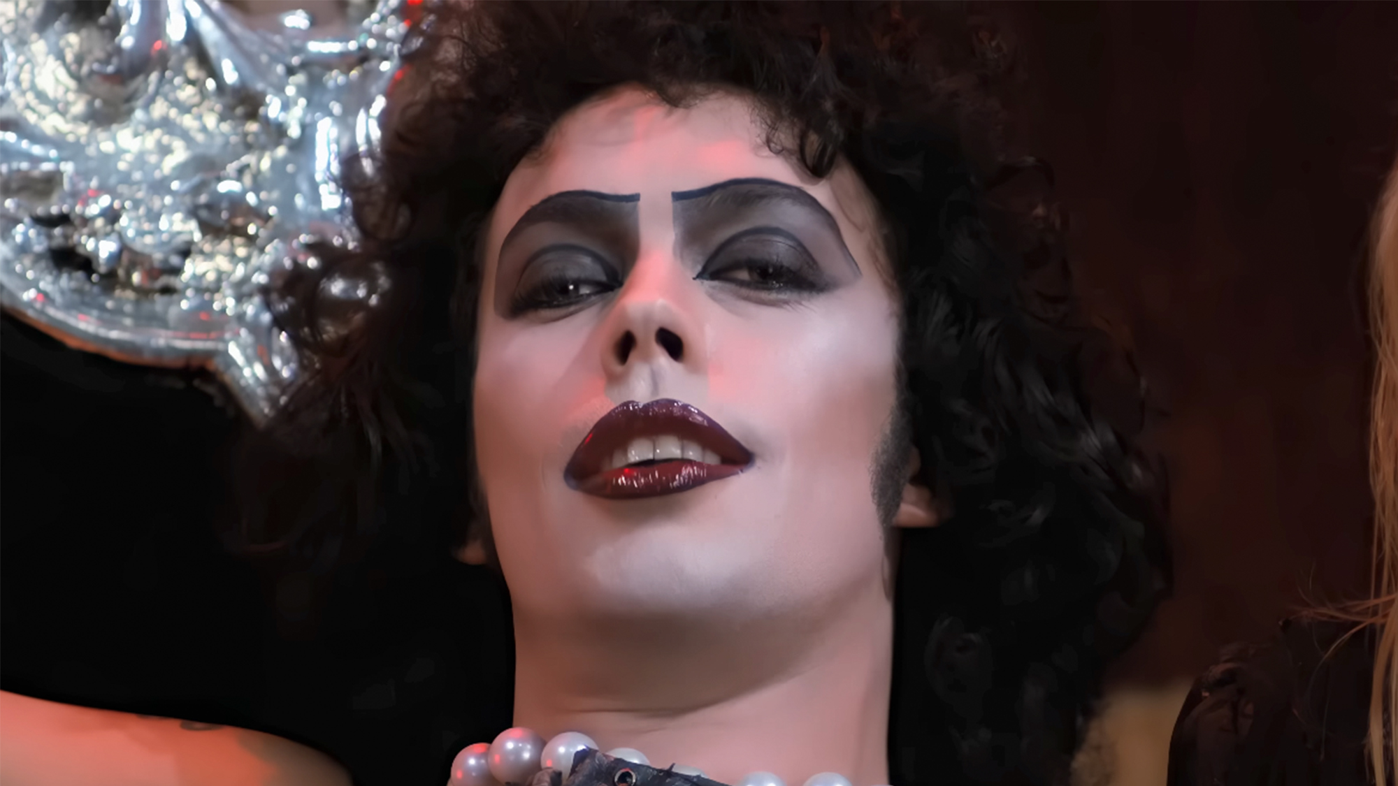 A close up of Time Curry smiling as Frank in The Rocky Horror Picture Show