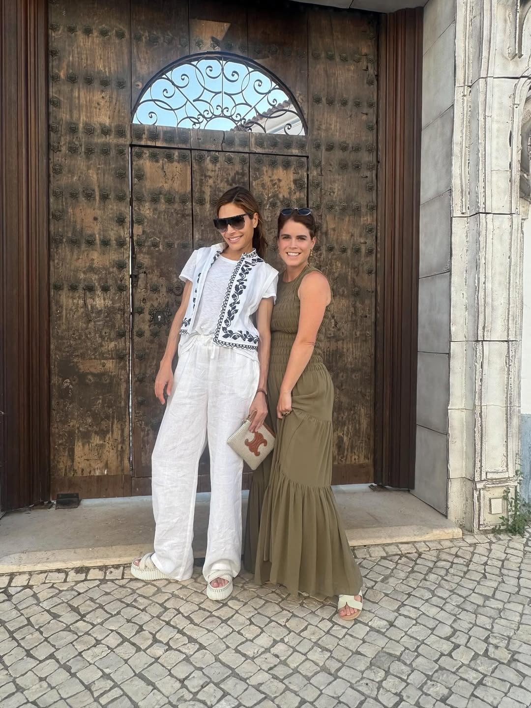 Princess Eugenie wearing a long green dress standing in front of a door with Ayda Field Williams
