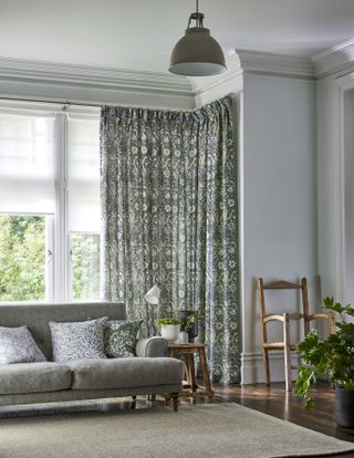 Patterned living room curtains in soothing gray with coordinating cushions on gray couch.
