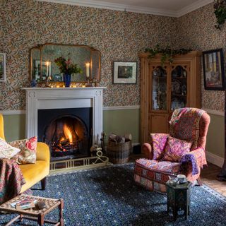 Living room with christmas tree and fireplace and traditional wallpaper with fruit print and dado rail
