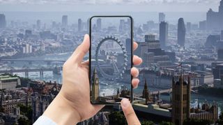 Een telefoon in iemands hand voor de skyline van Londen