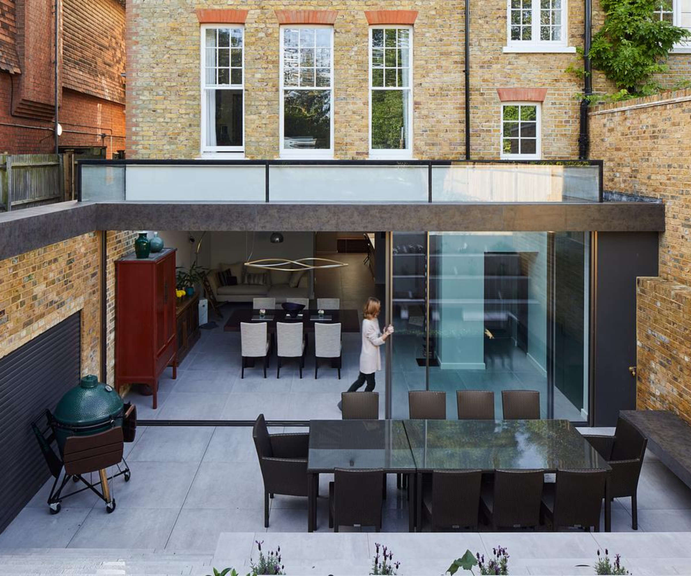 lower ground level single storey extension with metal cladding, glass box roof and large sliding doors leading to courtyard and dining space