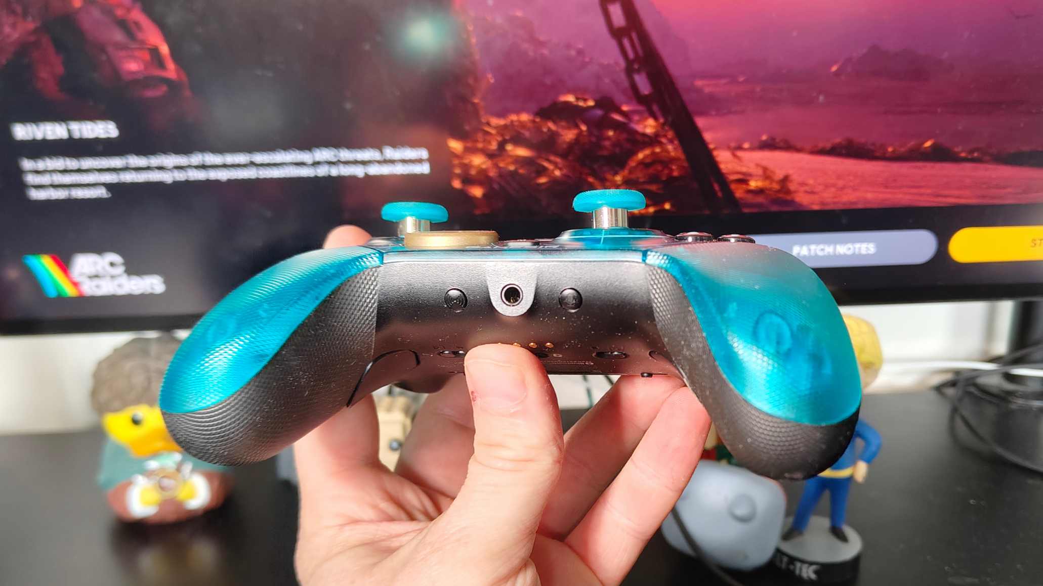 The GameSir G7 Pro 8k in a man's hand, showing its headphone port.