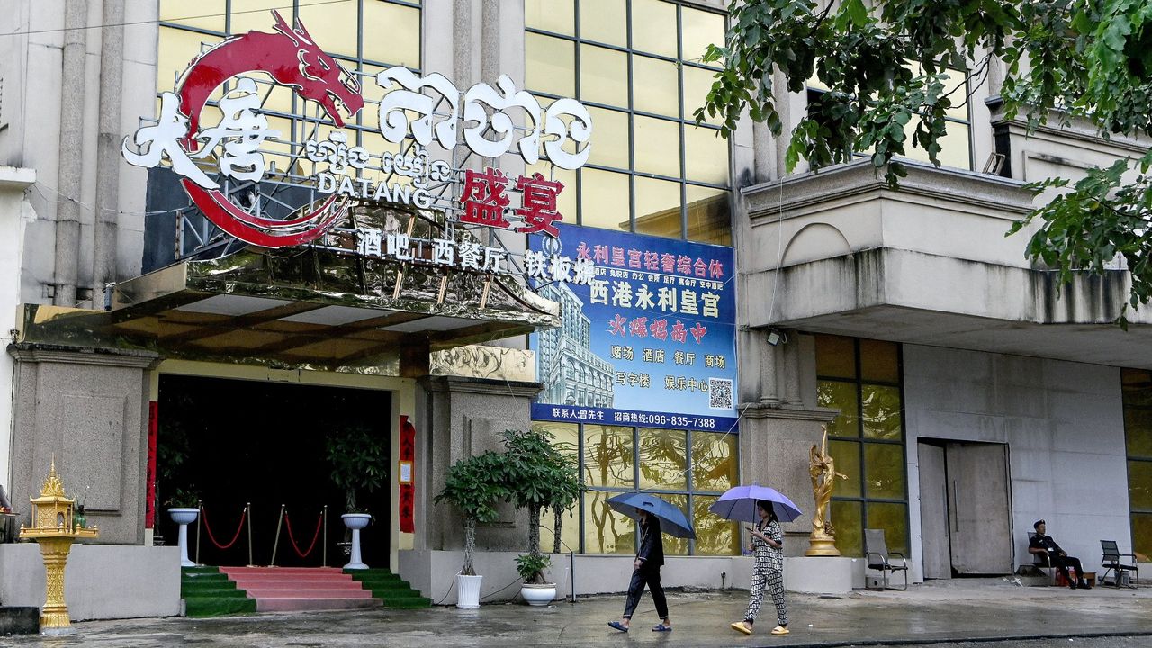 Locals walk past a casino shut down by the police in Sihanoukville, Cambodia, a centre for illicit gambling and scams