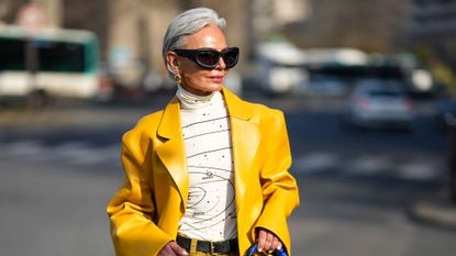 best spfs for mature skin - Grece Ghanem wears black sunglasses from Off-White, yellow suit, white top and red lipstick - gettyimages 1470920013