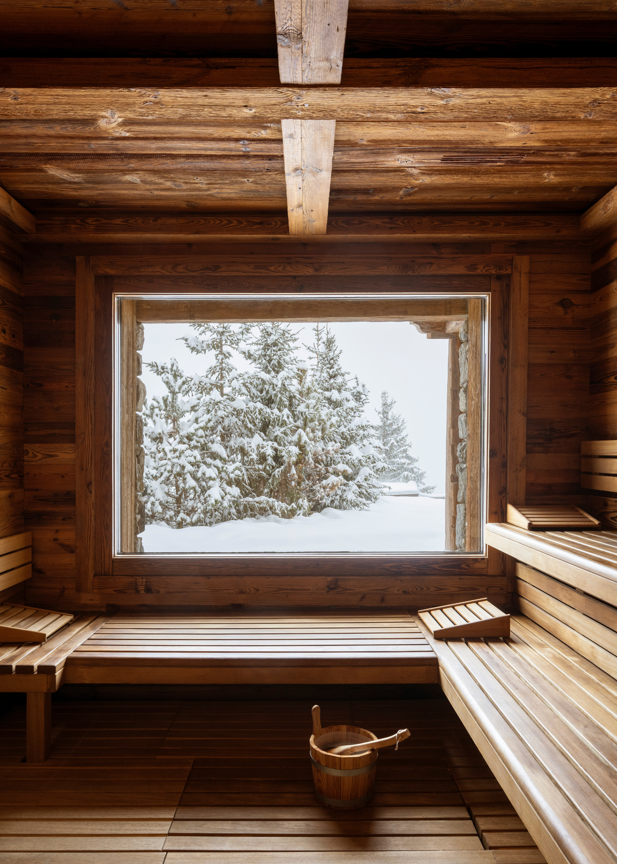 The sauna at Refuge de la Traye with a central window to view the snowy trees and mountains outside