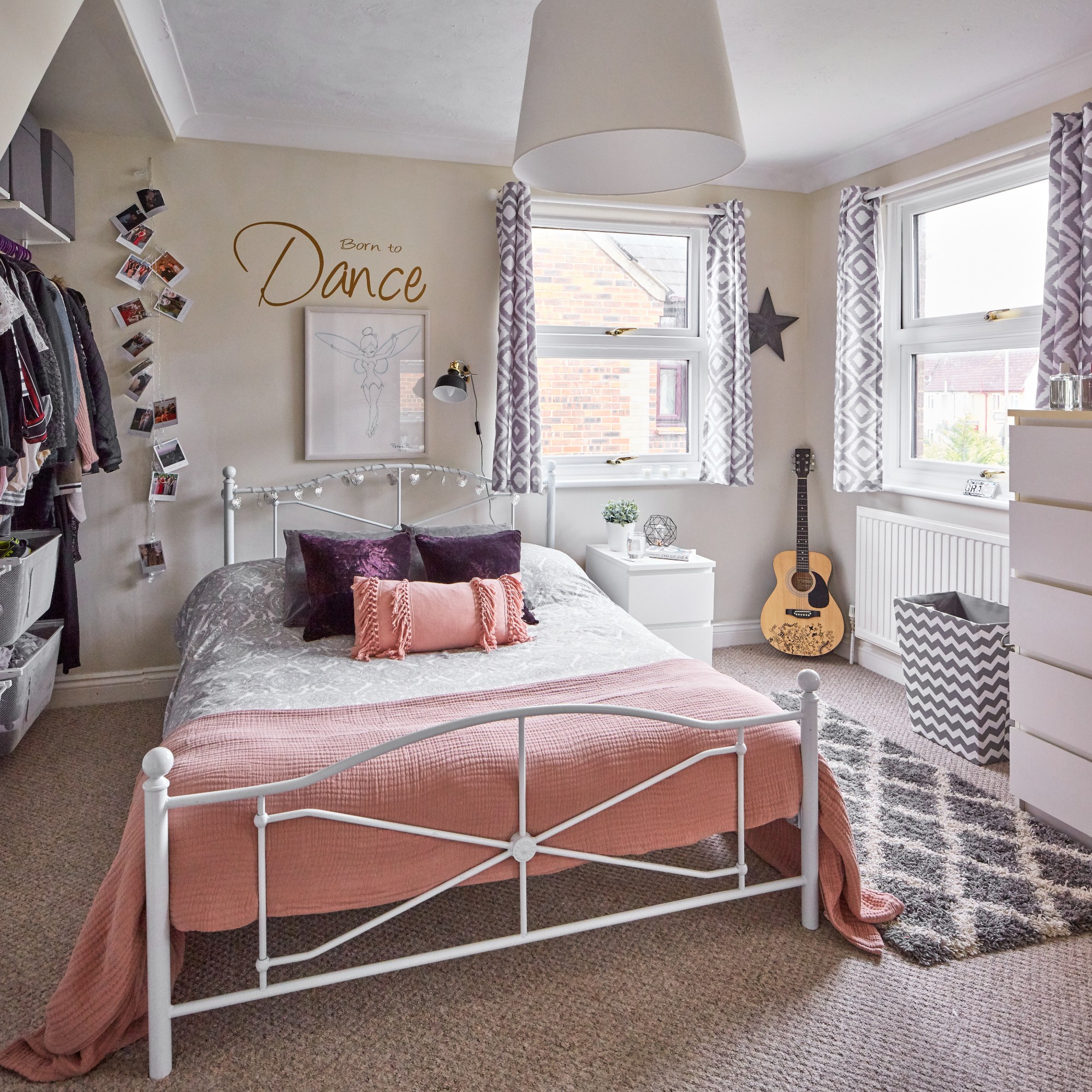 A teenage girl's bedroom with a white metal bed and pink throw on top