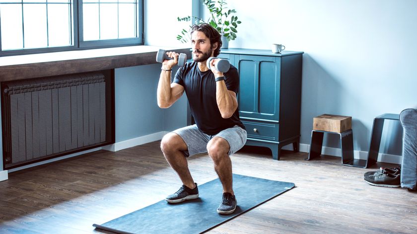 Man performing a dumbbell squat at home