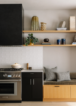 A small kitchen with an overhead exhaust and wooden panelled shelving