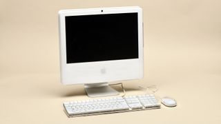 Apple iMac 17 inches 2006 with keyboard and mouse isolated on beige background