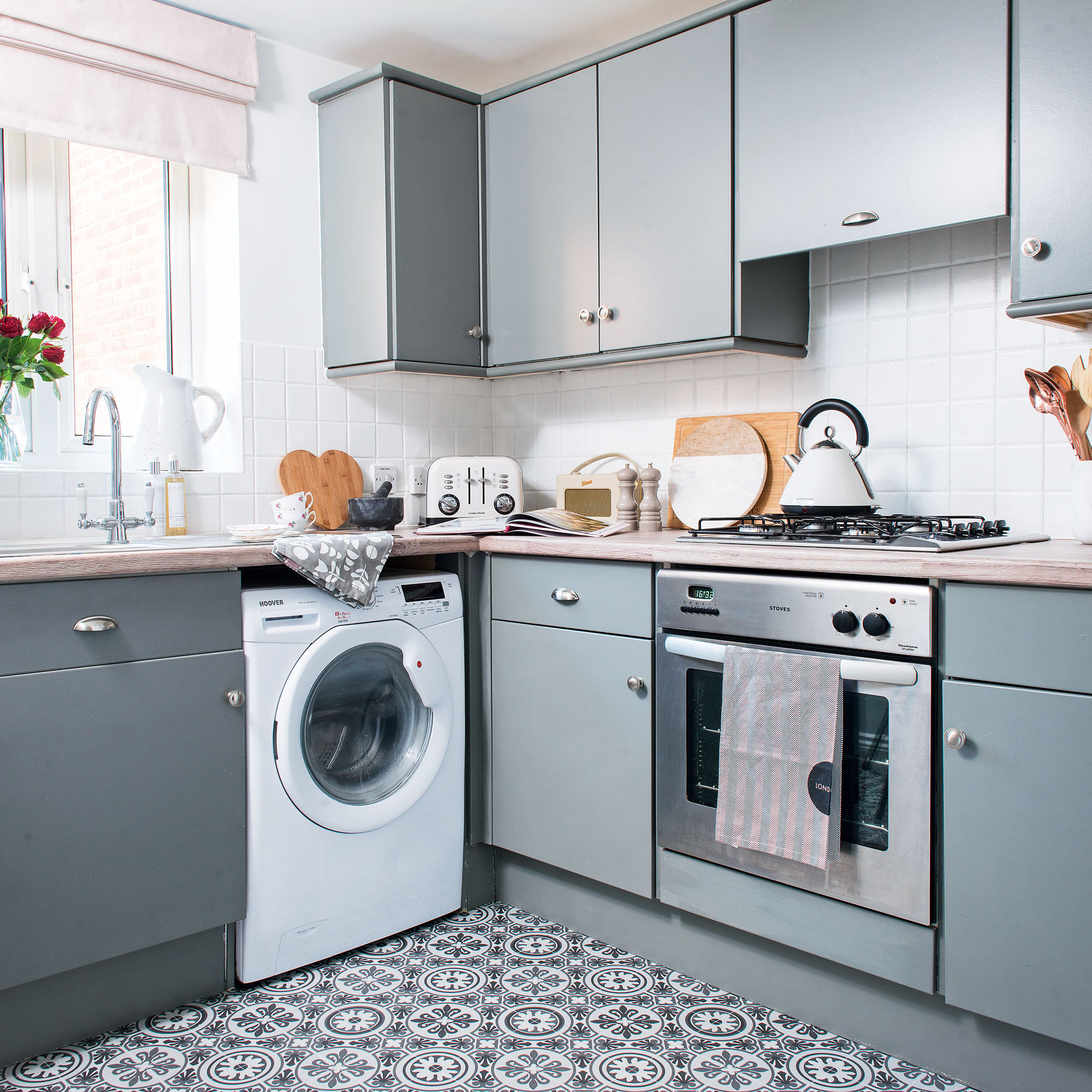 Blue kitchen with patterned flooring and white tiles