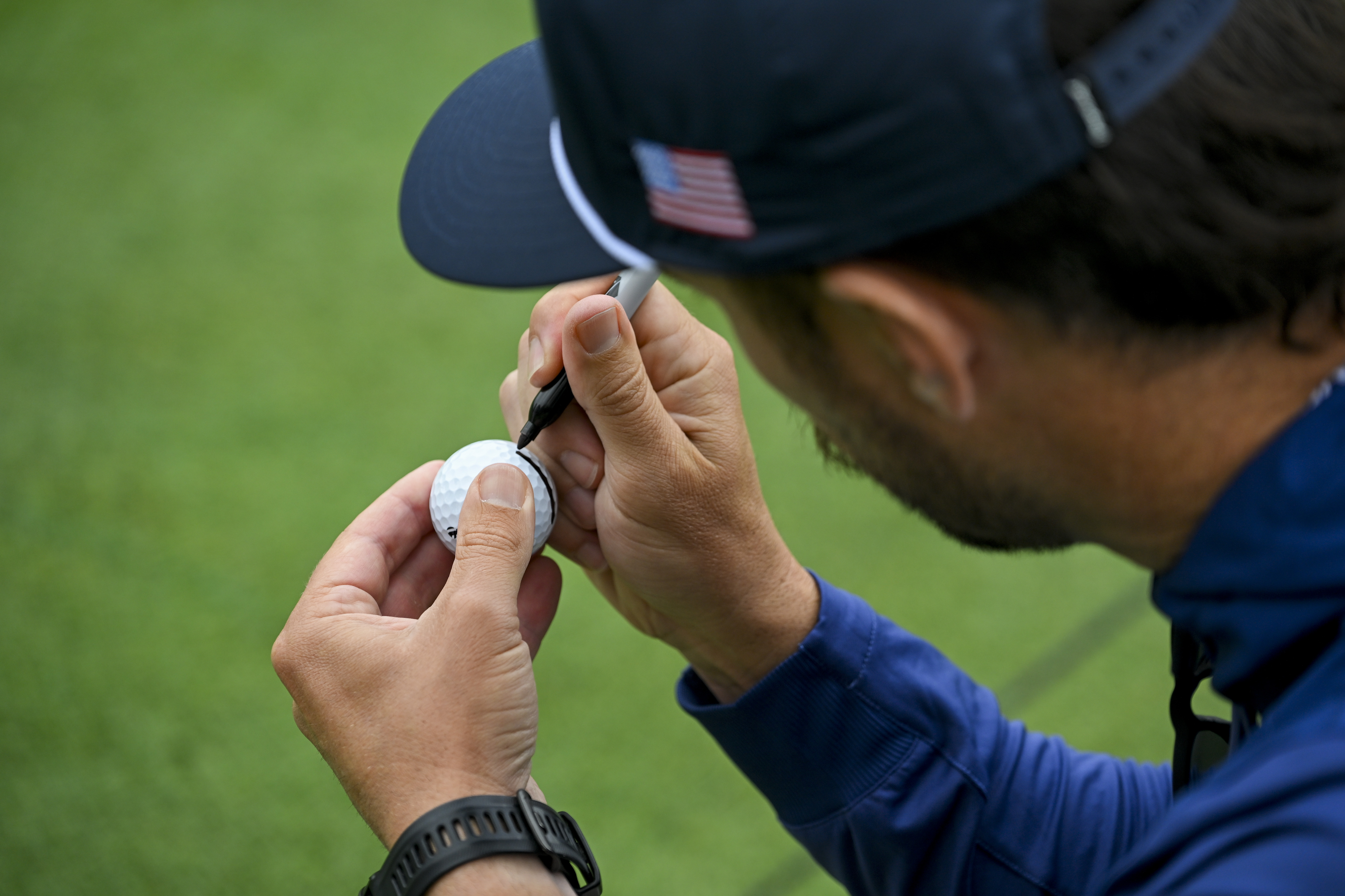 A golfer marking their golf ball