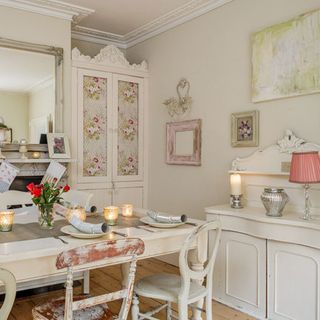 dining room with dining table and chairs with white wall and frames on wall